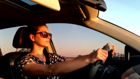 Fahren.-Zielorientierte-Frau-in-ihren-30er-Jahren-fahren-während-der-goldenen-Stunde