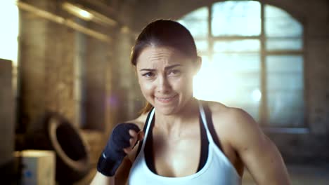 Hermosa-mujer-atlética-aire-de-golpes-con-sus-puños-como-parte-de-su-intensivo-entrenamiento-gimnasio-Cross.