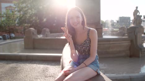 Young-beautiful-woman-eating-ice-cream-during-sunny-day,-outdoors.