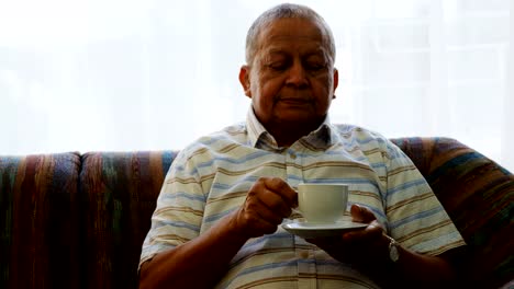 Retrato-de-senior-hombre-tomando-café-en-el-sofá-4k