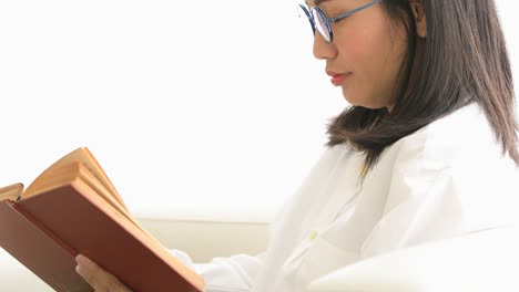 Cute-asian-woman-reading-a-book-with-smile-face-at-home.