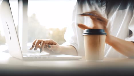 Female-hands-typing-and-making-notes