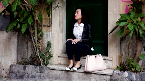 Young-Chinese-woman-sits-on-a-step-and-despairs