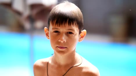 wet-serious-boy-after-a-swimming-pool-looks-at-the-camera