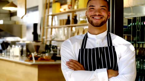 Portrait-of-smiling-waiter-standing-with-arms-crossed-4k