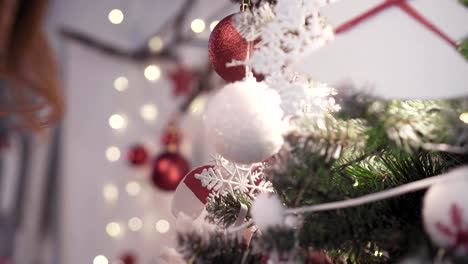 Una-mujer-joven-prettty-decora-un-árbol-de-Navidad-con-juguetes