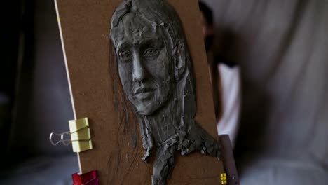 Close-up-of-Sculptor-creating-sculpture-of-human's-face-on-canvas-in-art-studio