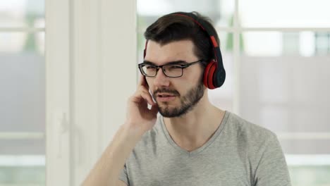 Guy-wearing-eyeglasses-listen-music-in-headphones