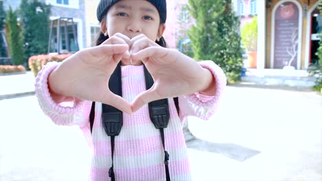 4K-Asian-little-girl-showing-hand-make-heart-shape-with-happiness-in-vacation-travel