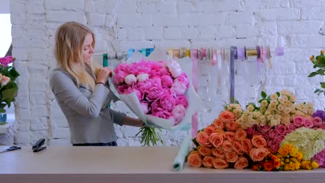 Blumengeschäft-wickelt-Blumen-in-Geschenkpapier-im-Blumenladen