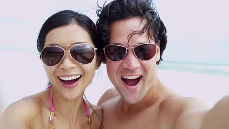 Portrait-young-Asian-Chinese-couple-filming-beach-selfie