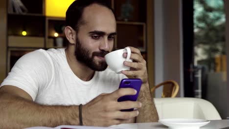 Hombre-usando-app-smartphone-tomando-café,-mensajes-de-texto-en-el-teléfono-móvil