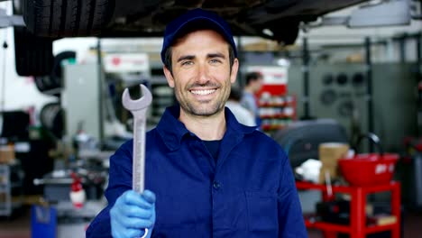 Portrait-of-a-young-beautiful-car-mechanic-in-a-car-workshop,-in-the-background-of-service.-Concept:-repair-of-machines,-fault-diagnosis,-repair-specialist,-technical-maintenance-and-on-board-computer