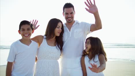 Portrait-of-Spanish-family-waving-hands-on-holiday