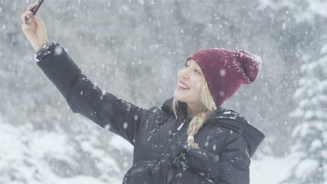 Portrait-shot-of-a-beautiful-young-Asian-woman-taking-a-selfie-on-a-snowy-day