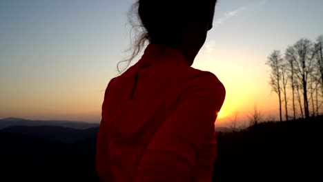 Junge-sportliche-Frau-läuft-im-Freien-bei-Sonnenuntergang-in-Berglandschaft.