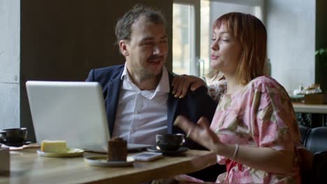 Cheerful-Couple-Having-Video-Call-in-Cafe