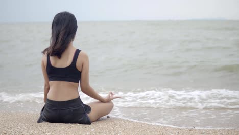 Joven-de-asia-practicando-yoga-en-el-beach.4K-resolución