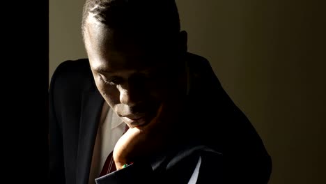 Thoughtful-worried-young-black-business-man-in-the-dark