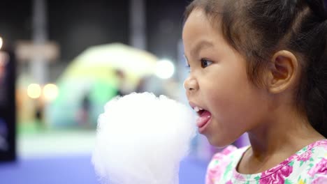 Kleines-Mädchen-eine-Zuckerwatte-Essen