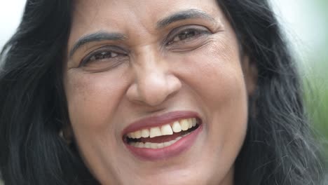 Close-up-shot-of-mature-happy-beautiful-Indian-woman-smiling-in-the-streets-outdoors