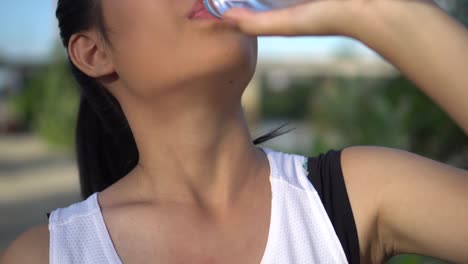 Young-woman-drinking-water-after-exercise