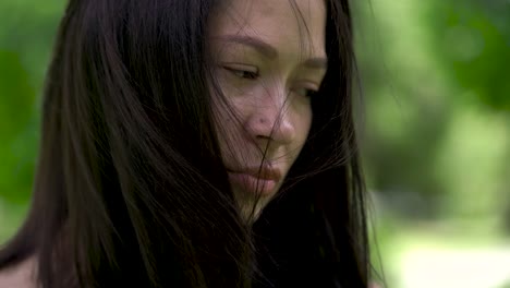 Un-retrato-de-una-mujer-asiática-triste.-Viento-desarrolla-a-su-pelo.-Desesperanza-y-depresión-en-sus-ojos.