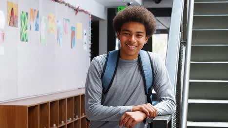 Porträt-von-männlichen-High-School-Schüler,-die-über-eine-Treppe-im-College-Gebäude-stehen