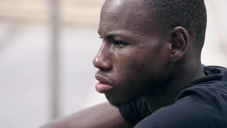 african-young-man-turning-his-head-and-staring-at-camera---outdoor