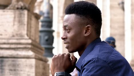 Confident-relaxed-young-black-african-man-turning-and-smiling-at-camera--outdoor