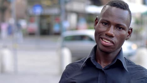 happy-young-black-african-man-smiling-at-camera--slow-motion--outdoor