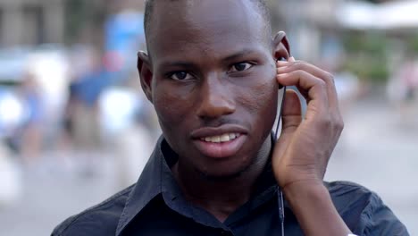 Young-black-man-putting-on-the-earphones-and-listening-music--slow-motion