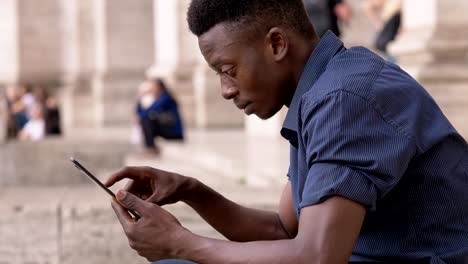 Attractive-young-african-man-usig-tablet-outdoor--profile