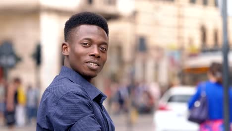 Handsome-confident-young-black-african-man-turning-and-smiling-at-camera-outdoor