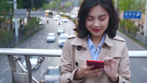 Mujer-joven-usando-teléfono-inteligente-en-la-ciudad