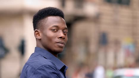 Attractive-young-black-african-man-turning-and-smiling-at-camera--outdoor