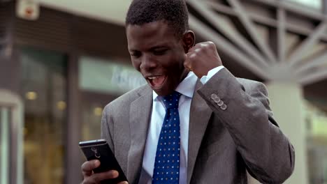 Success,winning.happy-young-black-business-man-rejoicing-for--good-news-on-phone