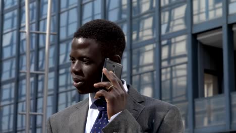 portrait-of-Succesful-confident-black--business-man-talking-by-phone-in-the-street