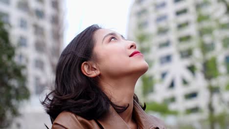 close-up-of-pretty-young-asian-woman-looking-up-smile-in-slow-motion