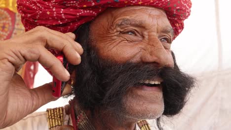 Hand-held-Rajasthani-elderly-male-on-a-smart-cell-phone-mobile-conversation