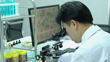 Male-scientists-looking-through-microscope-and-observe-in-modern-laboratory-or-medical-center.-Concept-of-science,-testing-development-and-lab-industry.