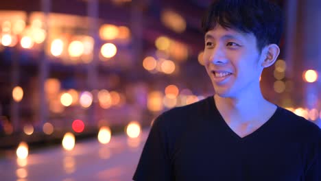 Happy-Asian-Man-Smiling-Outdoors-At-Night