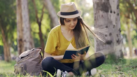 Junge-Frau,-die-ein-Buch-im-freien