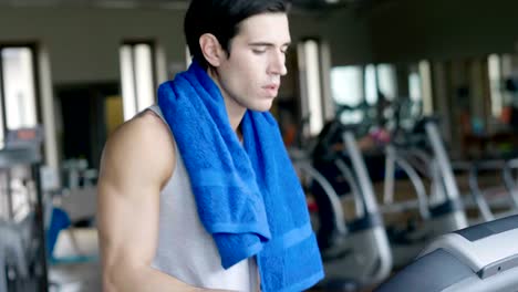 Un-chico-sin-camiseta-en-el-gimnasio,-entrena-su-cuerpo-para-mantenerse-en-forma-y-han-definido-los-músculos.-El-atleta-provoca-fatiga-y-cargas-pesadas.