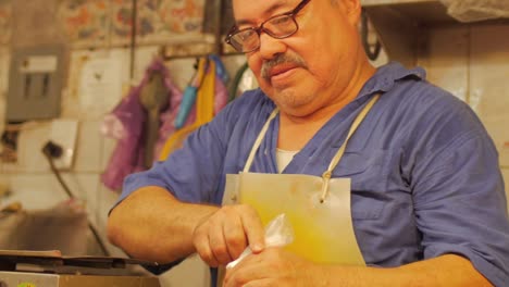 A-hispanic-man-with-a-mustache-giving-change-back-to-a-customer-in-a-fish-market-in-Mexico