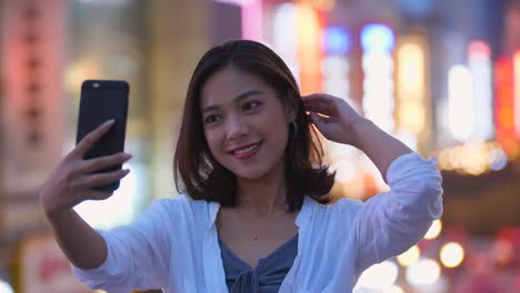 Pretty-young-woman-using-phone-taking-selfie