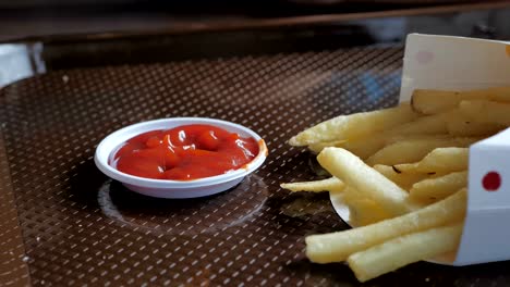 Nahaufnahme-der-Hand-des-jungen-Asiaten-essen-Pommes-und-Ketchup.-Video-Zeitlupe