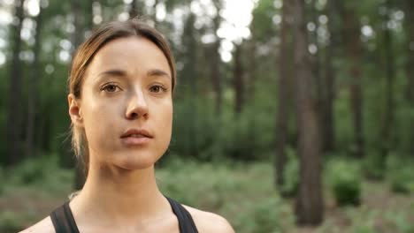 Mujer-sonriendo-para-la-cámara-en-el-bosque