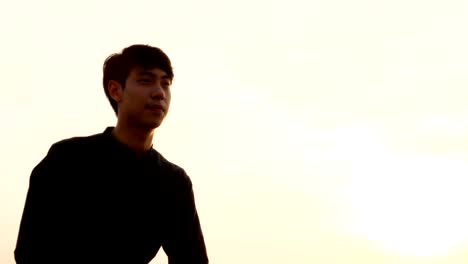 Young-asian-man-drinking-beer-at-rooftop-alone.