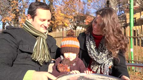 Schöne-Mutter,-Vater-und-schönes-Kind-mit-Spielplatz,-sonnigen-Familie-rotierende